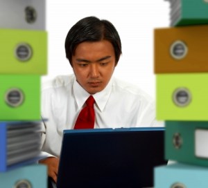 Man surrounded by stacks of files