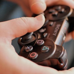 Hands holding Sony Playstation PS3 controller