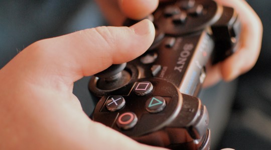 Hands holding Sony Playstation PS3 controller