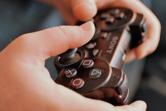Hands holding Sony Playstation PS3 controller